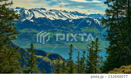 Mountain landscape with snow-capped peaks overlooking a serene lake and lush greenery in Switzerland during daytime Mountain landscape with snow-capped peaks overlooking a serene lake and lush greenery in Switzerland during daytime 132648077