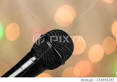 A close-up of a microphone on a concert stage. Spotlights in the blurred background. A close-up of a microphone on a concert stage. Spotlights in the blurred background. 132648143