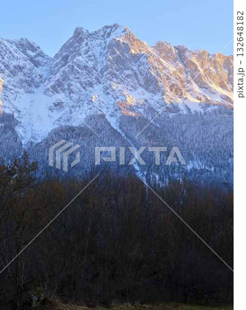 Snow-capped mountain peaks illuminated by the golden light during the early morning hours in a serene landscape 132648182