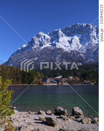 Scenic winter landscape with mountains and lake in a tranquil alpine setting during bright daylight Scenic winter landscape with mountains and lake in a tranquil alpine setting during bright daylight 132648215