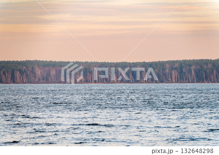 Autumn lake with trees on the shores. Reflection of blue sky with clouds in water. 132648298