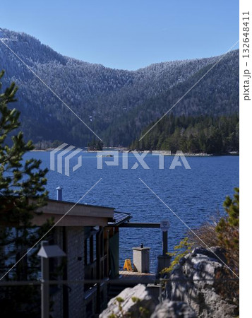 Snow-capped mountains and serene lake viewed from a cozy lodge on a clear winter day 132648411