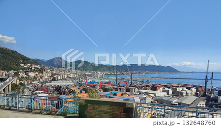 Salerno, Italy - Container ships, stacked cargo and cranes at the industrial port of Salerno, with trucks parked at the container terminal in front. 132648760