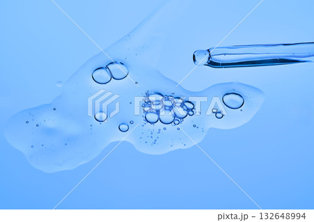 Dropper dropper with cosmetic serum on a blue background. 132648994