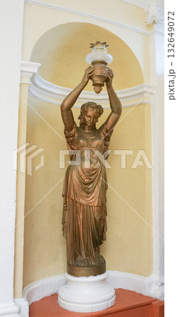 Bronze Statue Roman woman holding a torch, Lady lamp, Isolated on yellow wall background. Bronze Statue Roman woman holding a torch, Lady lamp, Isolated on yellow wall background. 132649072