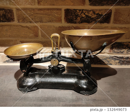 The ancient scales with the weight imbalance because a brass pendulum is on the left brass tray The ancient scales with the weight imbalance because a brass pendulum is on the left brass tray 132649073
