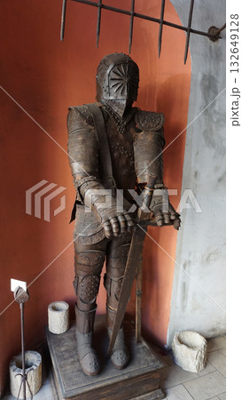 Medieval knight statue in armor stand outside at building. 132649128