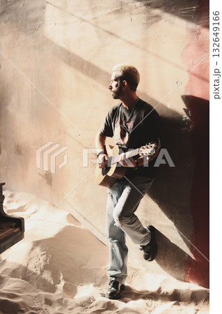 A talented musician passionately playing the guitar, illuminated by beautiful natural light 132649166