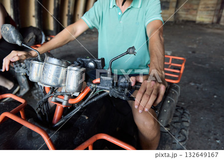 A skilled rider navigating an ATV in an expansive and abandoned warehouse setting 132649167
