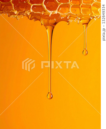 オレンジの背景にトロリと滴る蜂蜜のハニーディッパーとハニカムの甘い至福 オレンジの背景にトロリと滴る蜂蜜のハニーディッパーとハニカムの甘い至福 132649334