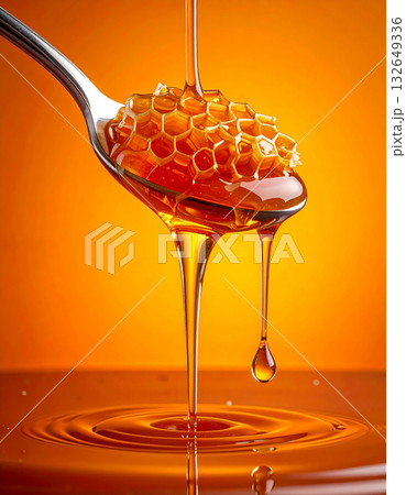 オレンジの背景にトロリと滴る蜂蜜のハニーディッパーとハニカムの甘い至福 132649336