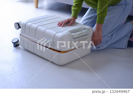 Young women packing luggage for holiday trip. Young women packing luggage for holiday trip. 132649467