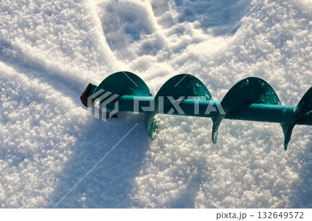 Teal Ice Fishing Auger Drill Blade Resting on Fresh Snow Surface Teal Ice Fishing Auger Drill Blade Resting on Fresh Snow Surface 132649572