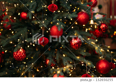 Detailed close-up of a vibrant Christmas tree with deep green needles, glowing yellow string lights Detailed close-up of a vibrant Christmas tree with deep green needles, glowing yellow string lights 132650255