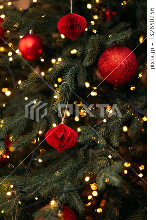 a festive Christmas tree decorated with red ornaments, glowing fairy lights, and natural green pine needles a festive Christmas tree decorated with red ornaments, glowing fairy lights, and natural green pine needles 132650256