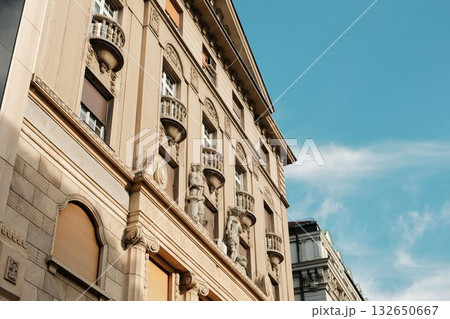 Elegant facade of classic architecture with balconies and sculptures under blue sky in Belgrade, Serbia country 132650667
