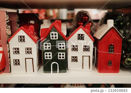 Cute ceramic decorative houses in red, green, and white Christmas colors displayed on shelf 132650685