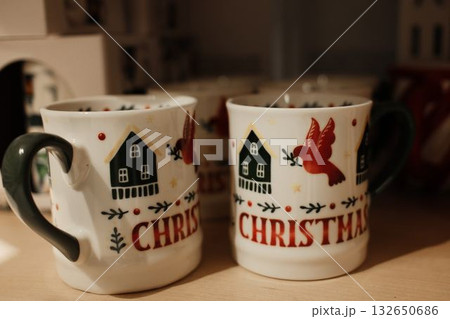 Detailed view of a white Christmas mug decorated with a red bird and green house illustration 132650686