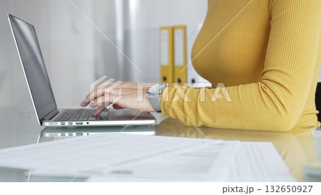 Woman working on laptop, typing on keyboard in office, managing business documents on desk, focusing on digital marketing communication and online data entry Woman working on laptop, typing on keyboard in office, managing business documents on desk, focusing on digital marketing communication and online data entry 132650927