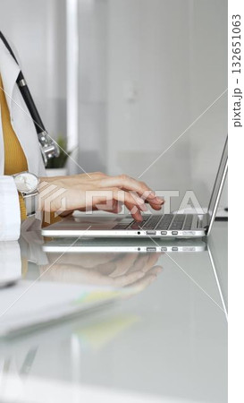 Female doctor working on laptop, managing patient data, writing prescriptions in clinic and filling out patient medical records. Concept of medicine, healthcare and science 132651063