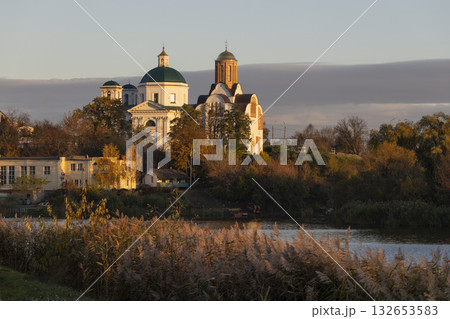 An evening view of a church on the riverbank. Autumnal cloudy weather, sunny. 132653583