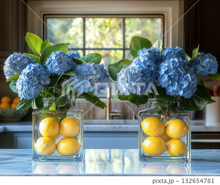 Glass vases hold vibrant blue hydrangeas and fresh lemons, citrus freshness creating fresh, bright, and creative kitchen Glass vases hold vibrant blue hydrangeas and fresh lemons, citrus freshness creating fresh, bright, and creative kitchen 132654781