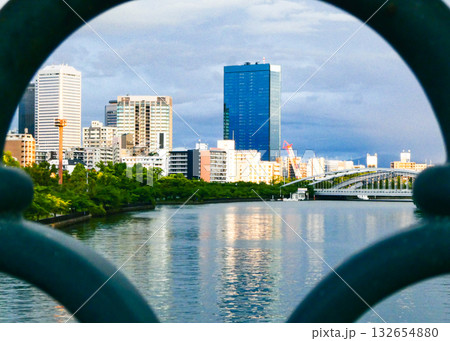 手すりのフレーム越しに見る川沿いの高層ビル群 132654880
