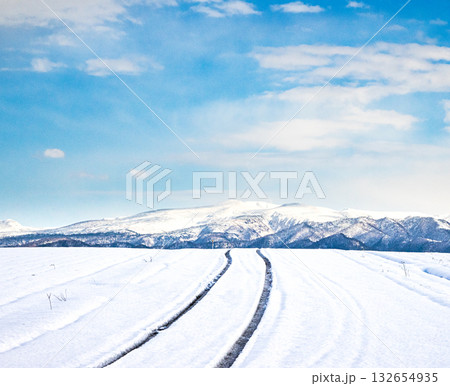 青空が見える冬の北海道の圧雪アイスバーンになった道と風景 132654935