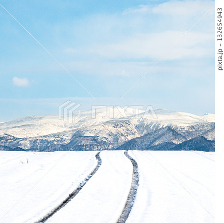青空が見える冬の北海道の圧雪アイスバーンになった道と風景 青空が見える冬の北海道の圧雪アイスバーンになった道と風景 132654943