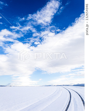 青空が見える冬の北海道の圧雪アイスバーンになった道と風景 132654946