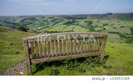 Empty wooden bench overlooking scenic green valley in North York Moors National Park 132655104