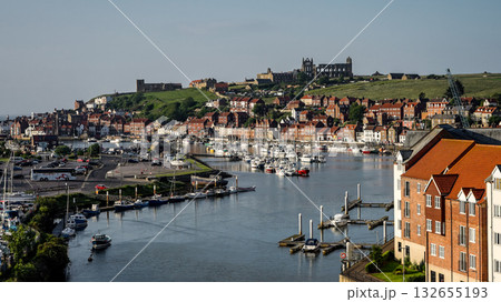 Whitby harbor with boats and Whitby Abbey dominating the skyline in North York Moors National Park 132655193