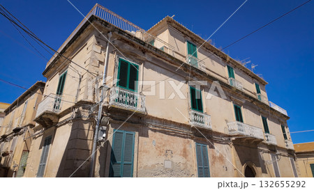 Old residential building with green shutters and white balconies in Tropea, Italy, showing traditional architecture Old residential building with green shutters and white balconies in Tropea, Italy, showing traditional architecture 132655292