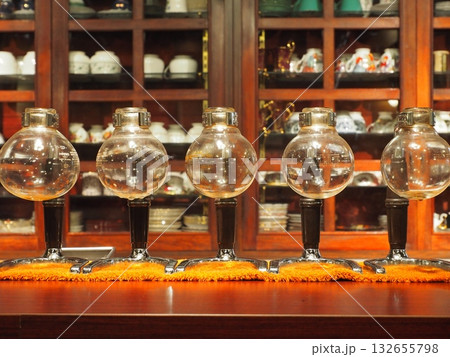 クラシックな喫茶店のカウンターに並ぶ、レトロなサイフォン用ガラス器具 132655798