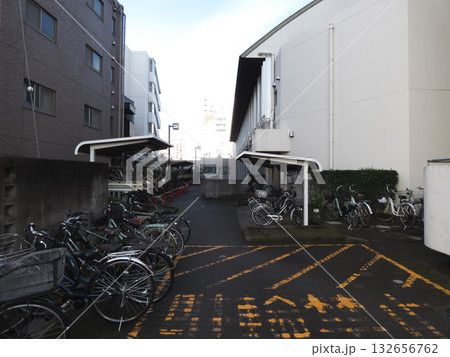 都市の建物間に並ぶ多数の自転車と屋根付き駐輪場 132656762