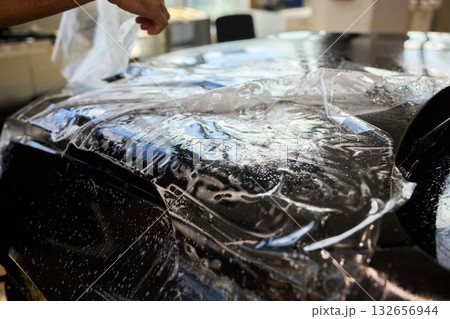 Applying a Protective Film on the Surface of Your Car for Enhanced Durability and Shine Applying a Protective Film on the Surface of Your Car for Enhanced Durability and Shine 132656944