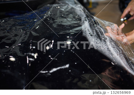 Applying a Protective Film on the Surface of Your Car for Enhanced Durability and Shine 132656969