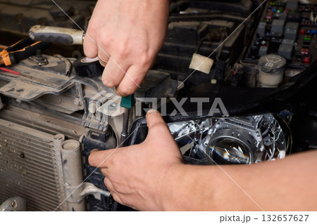 Careful precision is essential when installing a car headlight assembly for optimal performance 132657627