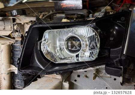Careful precision is essential when installing a car headlight assembly for optimal performance 132657628