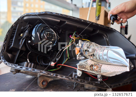 Careful precision is essential when installing a car headlight assembly for optimal performance 132657671