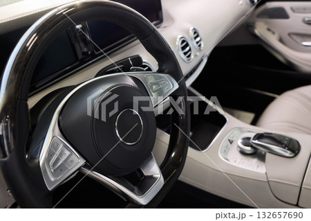 Closeup of a modern car steering wheel with control buttons for technology and convenience 132657690
