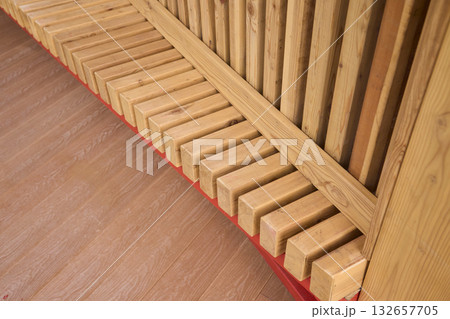 Wooden bench outdoors, Outdoor wooden bench with metal accents, Comfortable timber seating on urban plaza, Charming outdoor bench featuring red supports and warm wooden Wooden bench outdoors, Outdoor wooden bench with metal accents, Comfortable timber seating on urban plaza, Charming outdoor bench featuring red supports and warm wooden 132657705