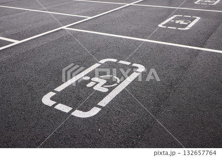 car parking space on asphalt, white worn markings, textured pavement, Handicap sign represents accessibility, inclusivity, equal rights, and consideration for individuals with disabilities car parking space on asphalt, white worn markings, textured pavement, Handicap sign represents accessibility, inclusivity, equal rights, and consideration for individuals with disabilities 132657764