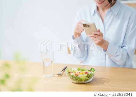 サラダを食べる女性・スマホ 132658041