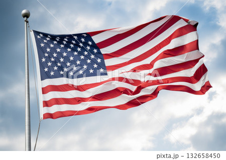 American flag waving proudly against a blue sky, representing patriotism, freedom, and national pride. 132658450