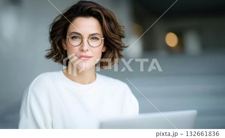 Young woman with laptop small business entrepreneur wearing glasses and white sweater confident professional portrait 132661836