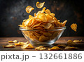 Clear glass bowl filled with golden, thin, and crispy potato chips 132661886