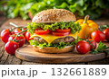 Appetizing cheeseburger among fresh vegetables and greens on a wooden table 132661889