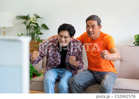 Exciting Sports Moment. Grandfather and grandson cheering while watching TV. Exciting Sports Moment. Grandfather and grandson cheering while watching TV. 132662576