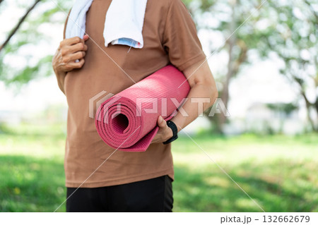 Yoga and Fitness. Senior man holding yoga mat in park after workout. Yoga and Fitness. Senior man holding yoga mat in park after workout. 132662679
